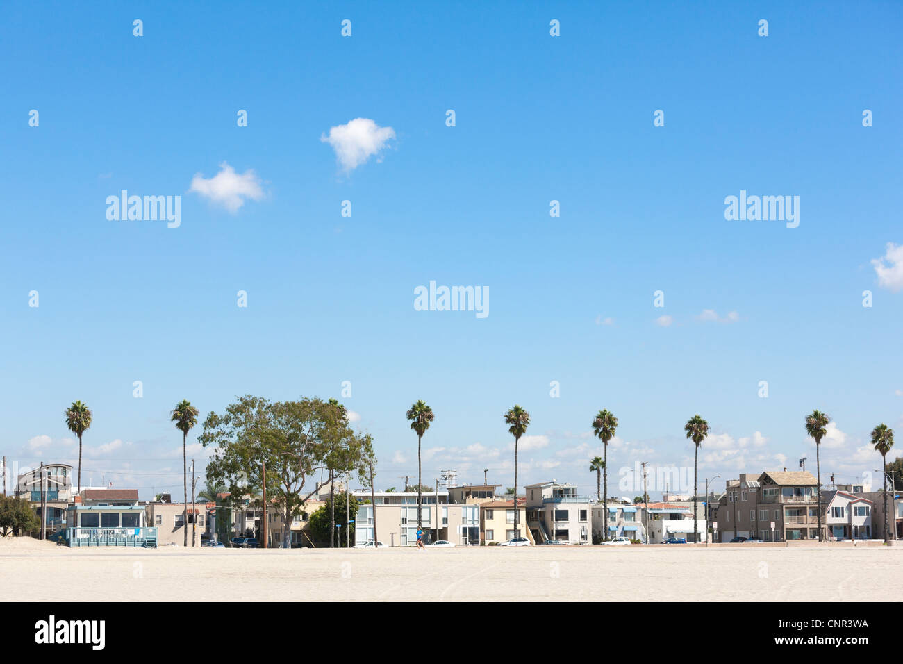 Long Beach California, East E Ocean Boulevard beach front homes. Looking out over the beachfront sand, with palm trees. Stock Photo