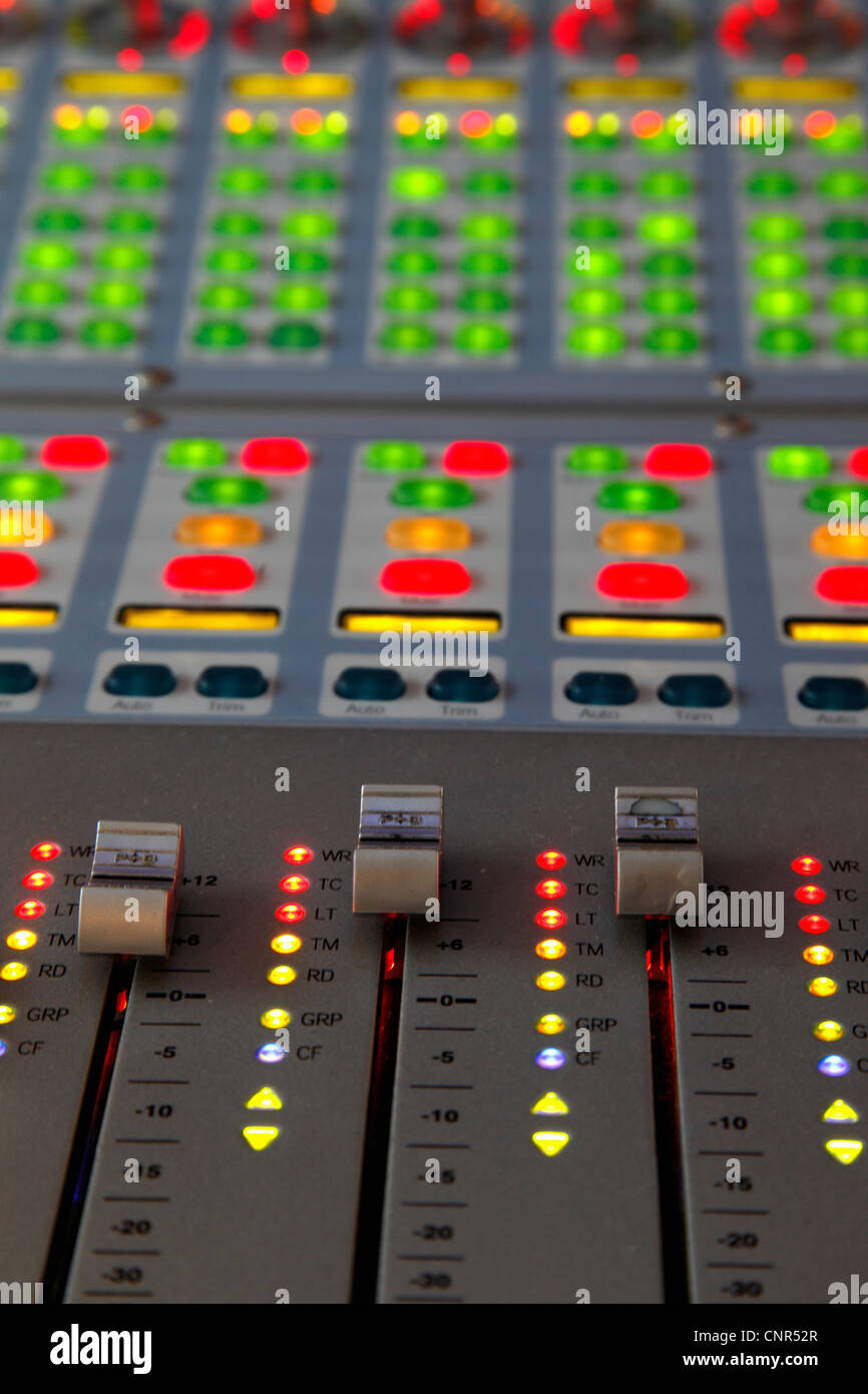Looking down at a professional music mixing desk lit up, close up Stock Photo