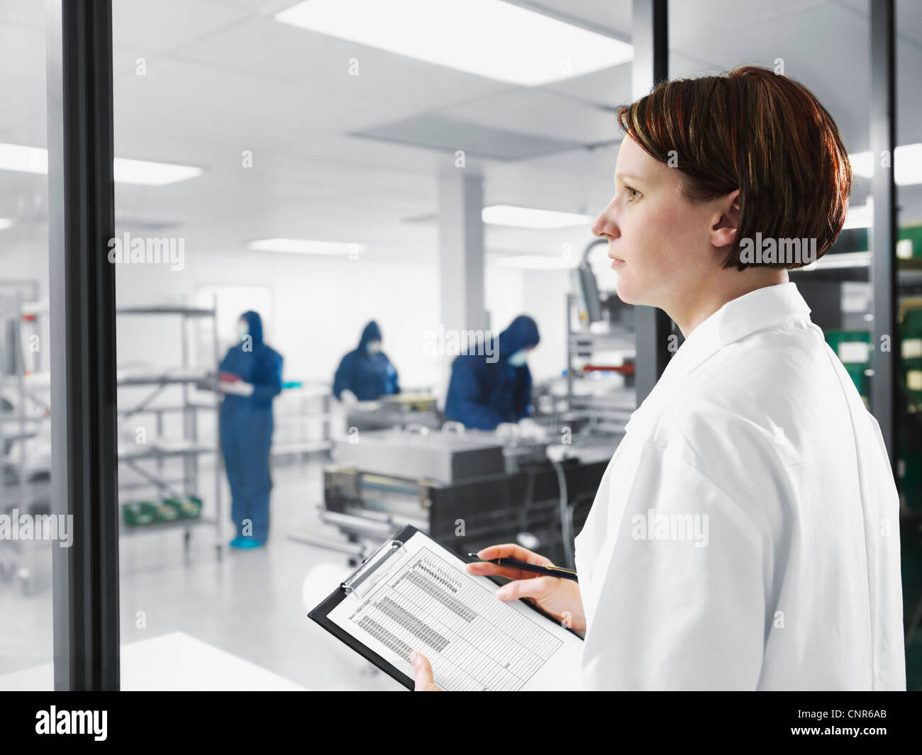 Scientist using clipboard in lab Stock Photo