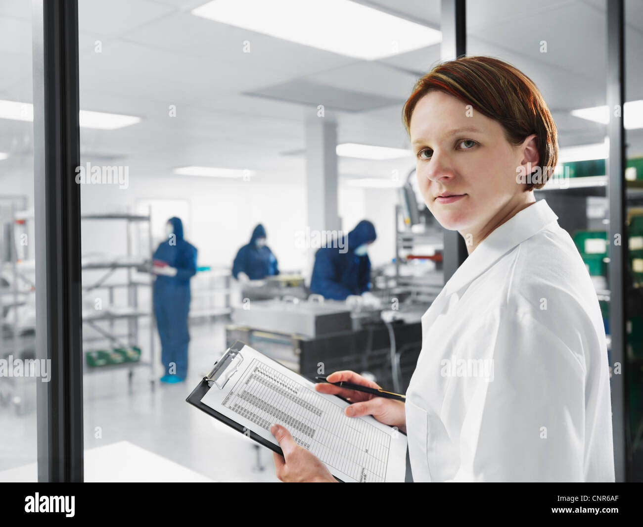 Scientist using clipboard in lab Stock Photo
