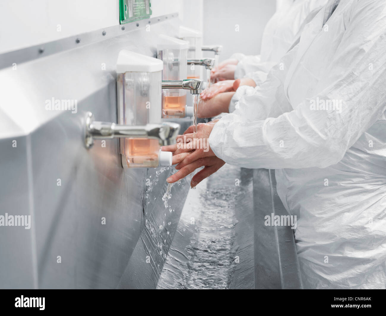 Scientists washing their hands in sink Stock Photo