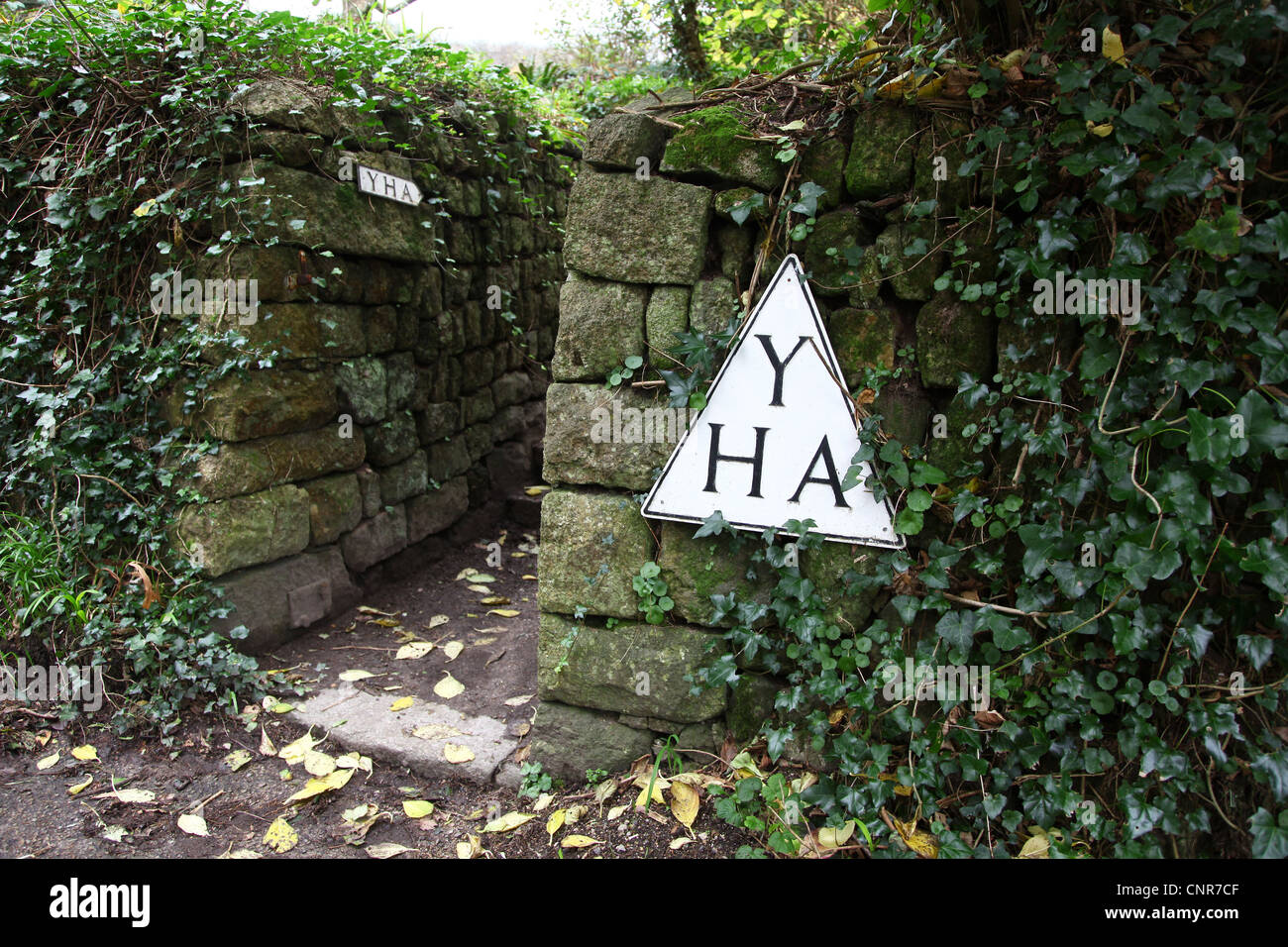 The triangular sign of the Youth Hostelling Association outside a youth hostel, England, UK Stock Photo