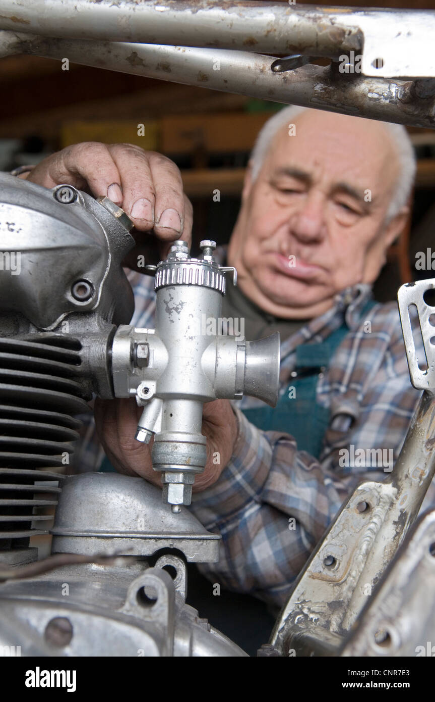 man repairing a vintage motorbike Stock Photo Alamy