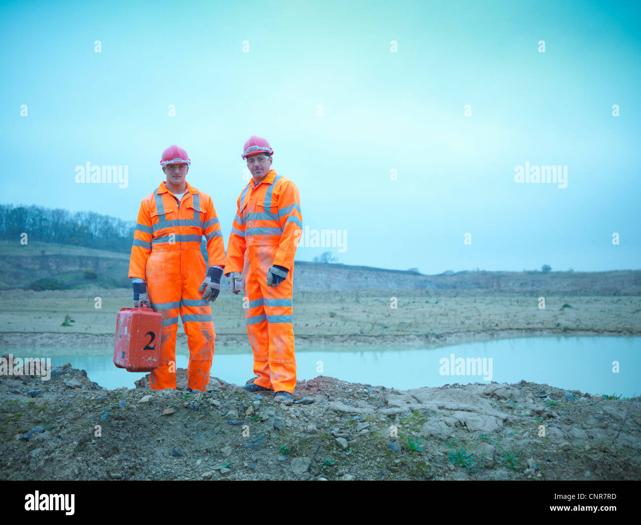 Workers standing on quarry rocks Stock Photo