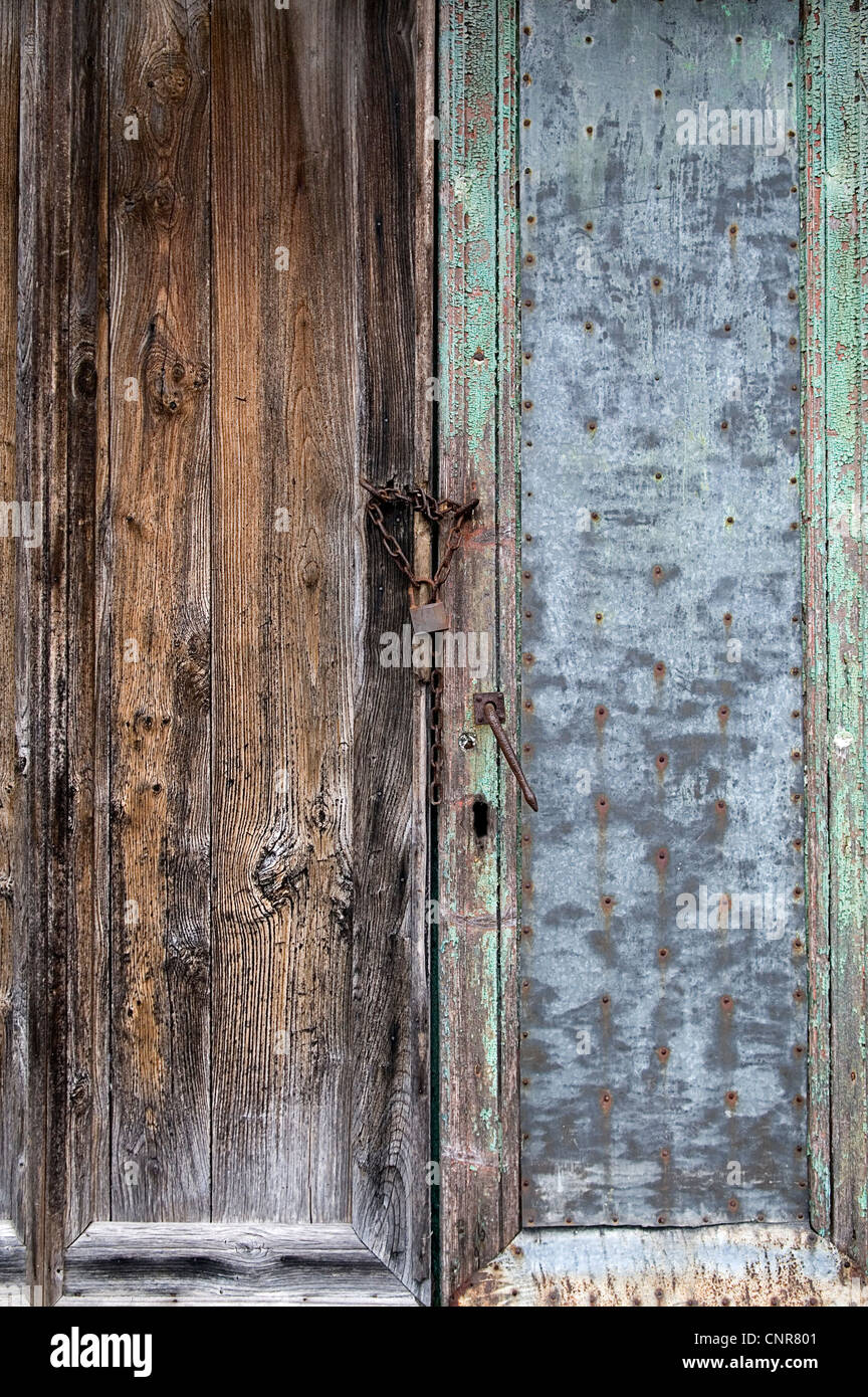 very old door in mixed materials with rusty lock Stock Photo