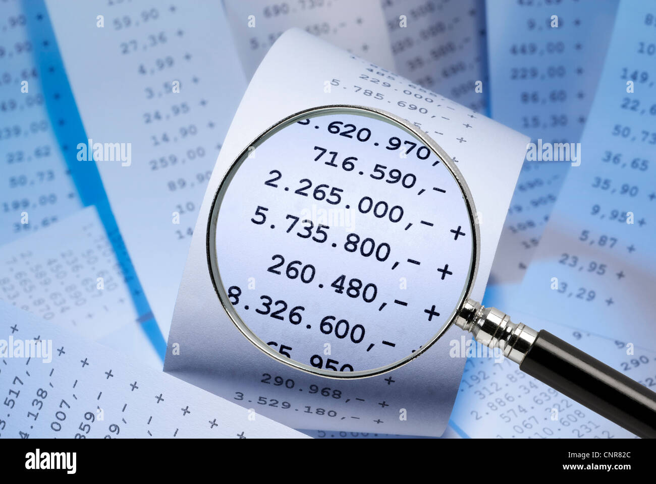 Magnifying glass focusing positive numbers on a receipt Stock Photo