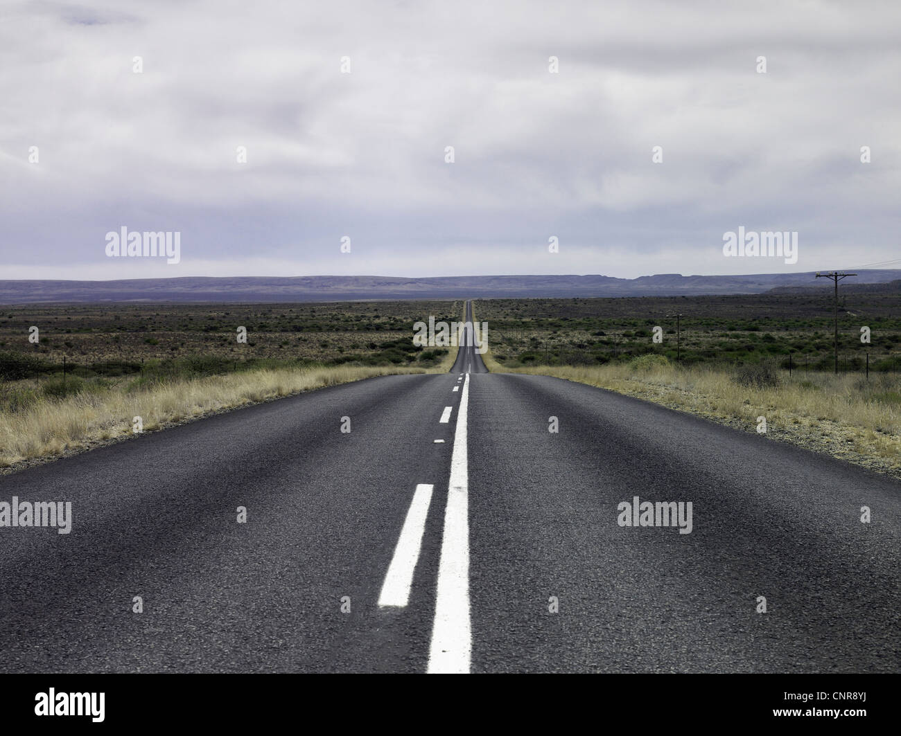 Empty road in dry rural landscape Stock Photo