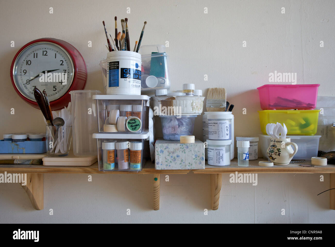 A shelf in an artist studio with boxes, brushes and tools Stock Photo