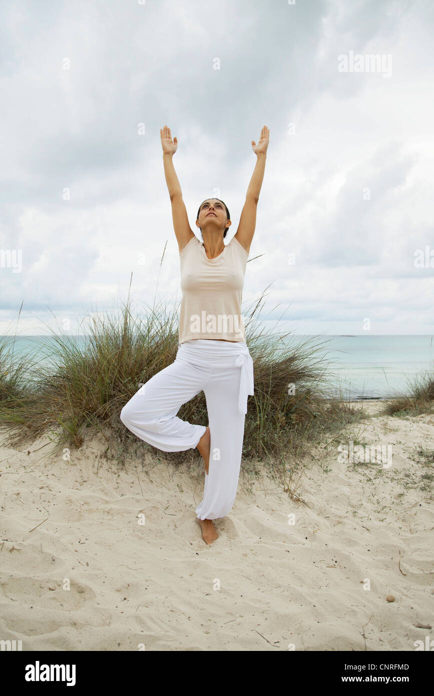 Mature woman in tree pose on beach, portrait Stock Photo - Alamy