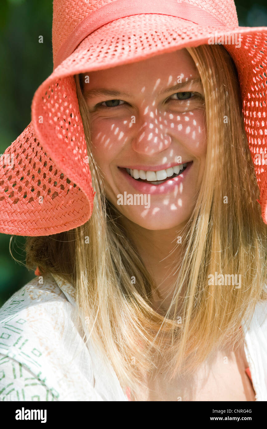 Smiling young woman with straw hat, portrait Stock Photo