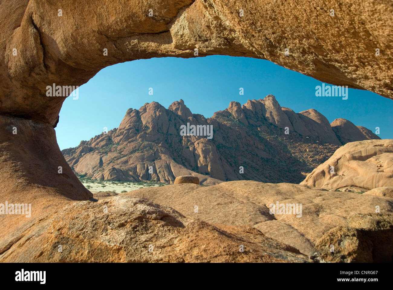 view through a rock arch on Spitzkoppe and Small Spitzkoppe, Namibia, Damaraland Stock Photo