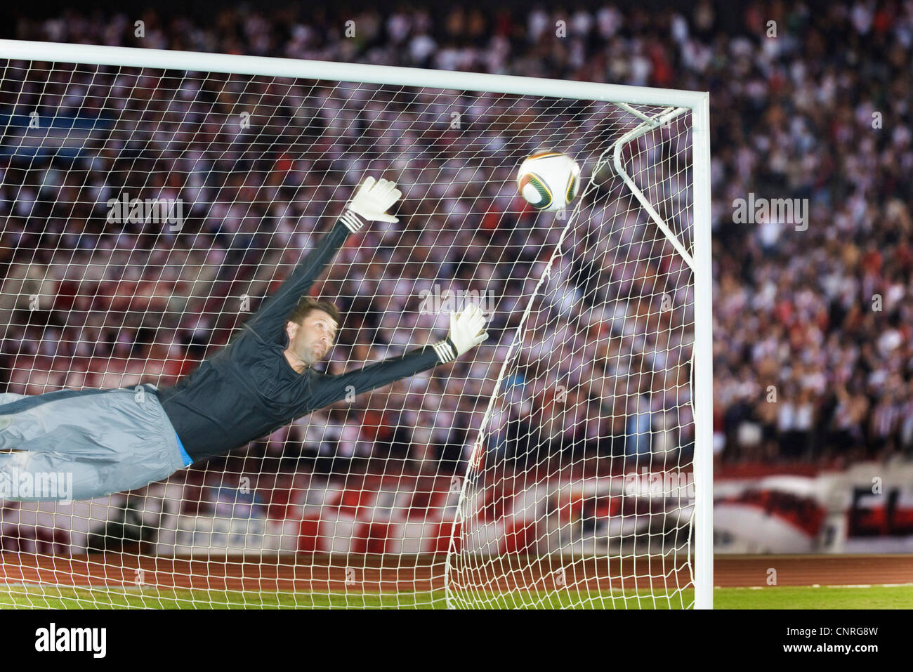 Soccer goalkeeper diving to block ball Stock Photo Alamy