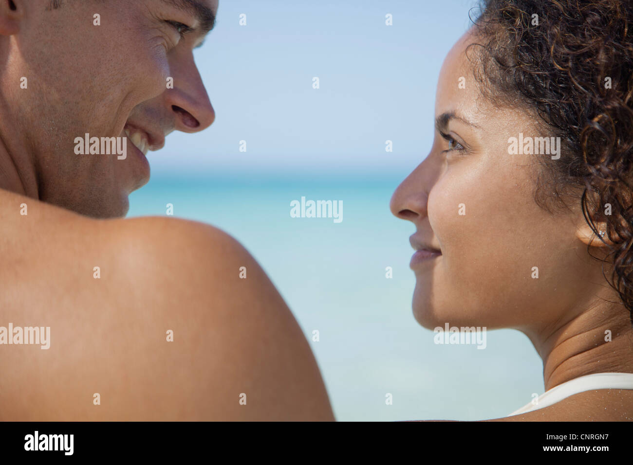 Couple smiling at each other at the beach Stock Photo