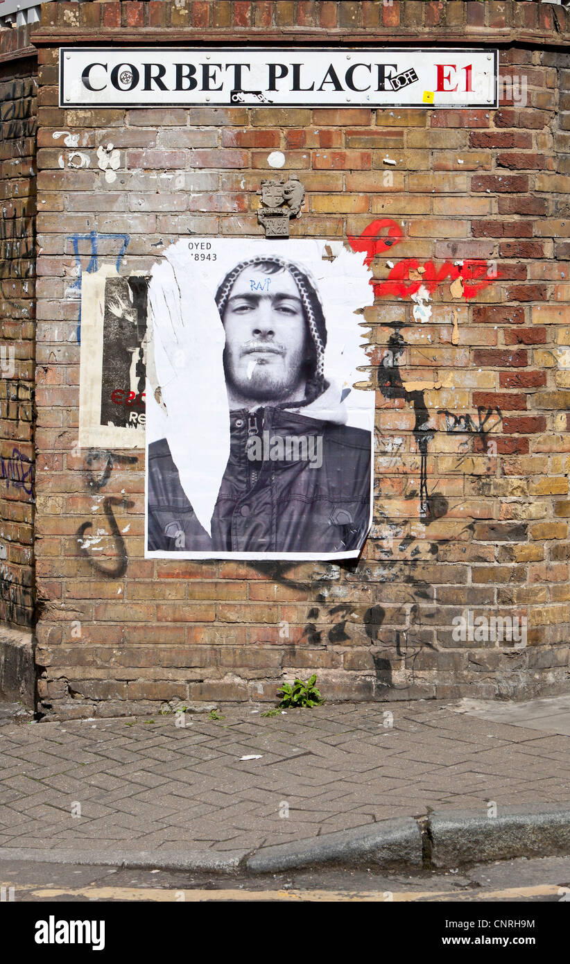 Torn poster on a brick wall, Corbet Place, E1, London, England, UK. Stock Photo