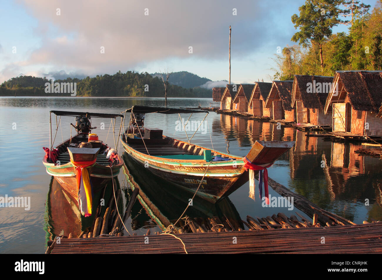 longtail boats and huts at Cheow Lan Lake in morning light, Thailand, Phuket, Khao Sok NP Stock Photo