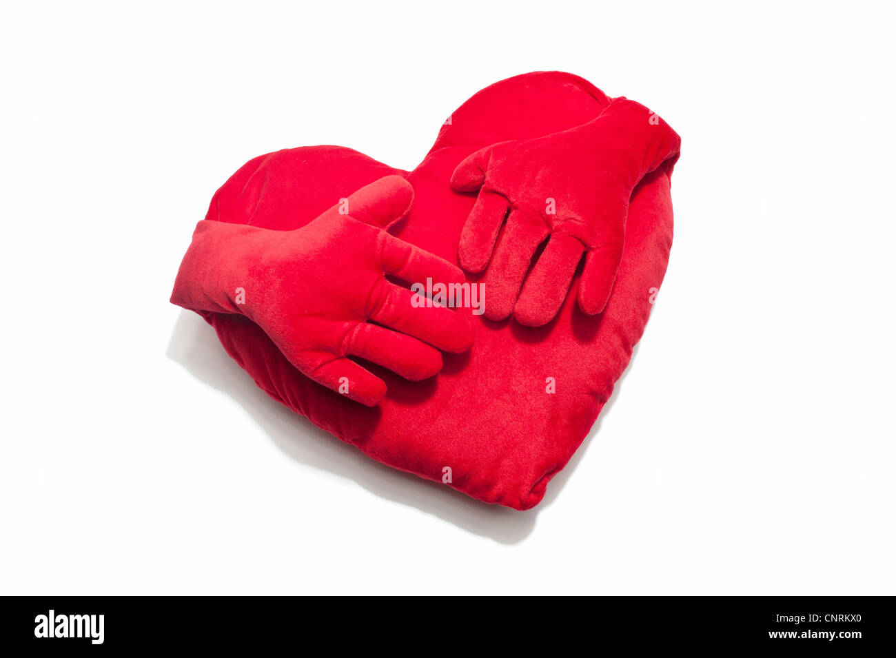A red heart shaped cushion with hands Stock Photo