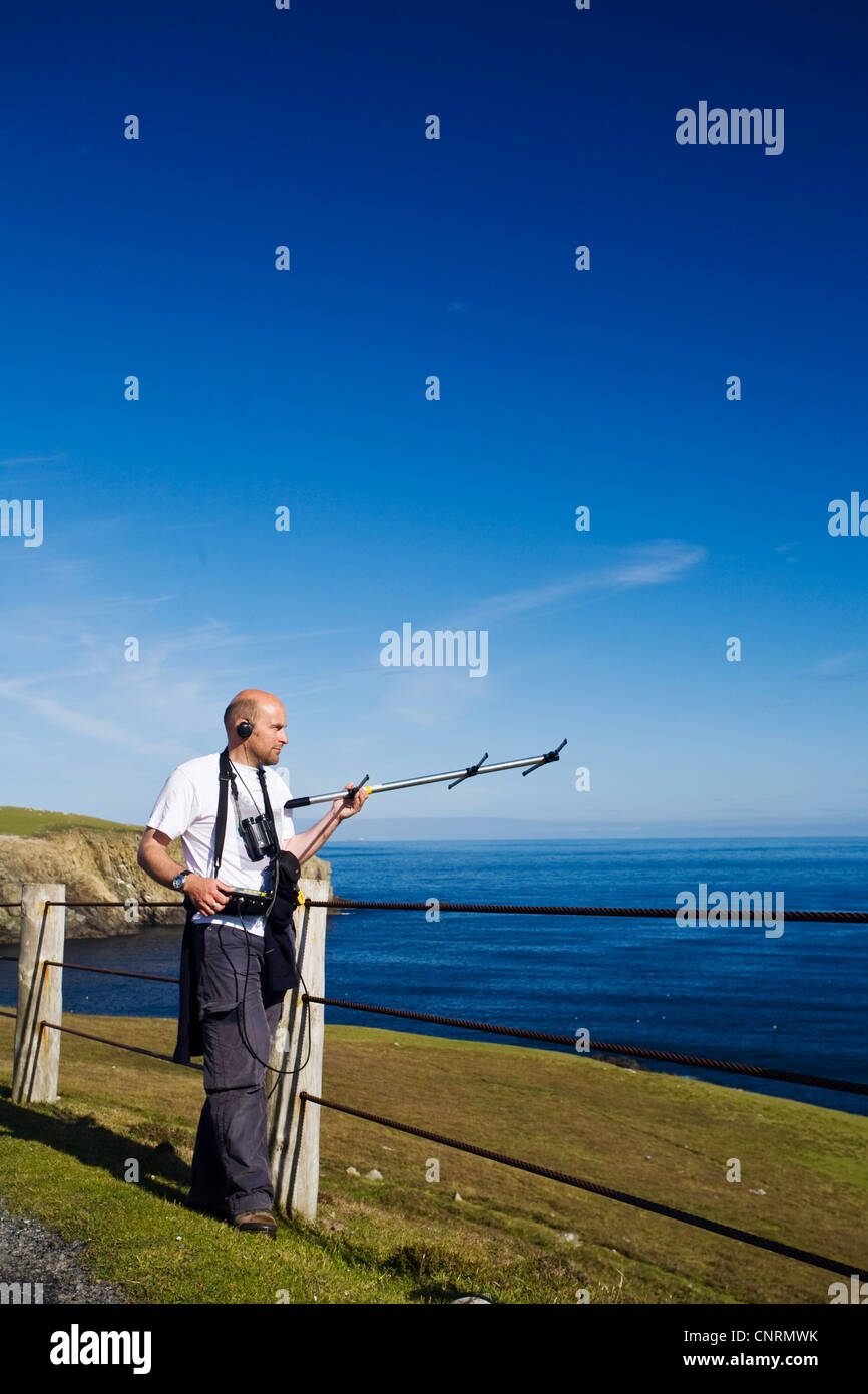 ornithologist with antenna for bird research at the coast of Fair Isle, United Kingdom, Scotland, Shetland Islands, Fair Isle Stock Photo