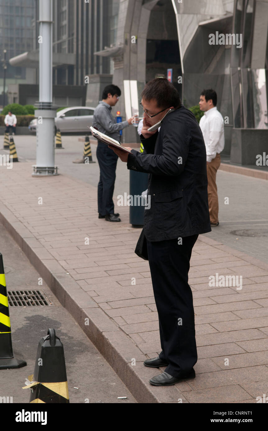 Chinese Businessman with phone and note pad and filofax Stock Photo
