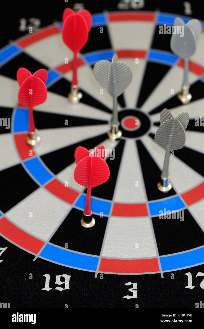 Magnetic darts with red or grey plastic flights placed onto a flexible dart board. Stock Photo