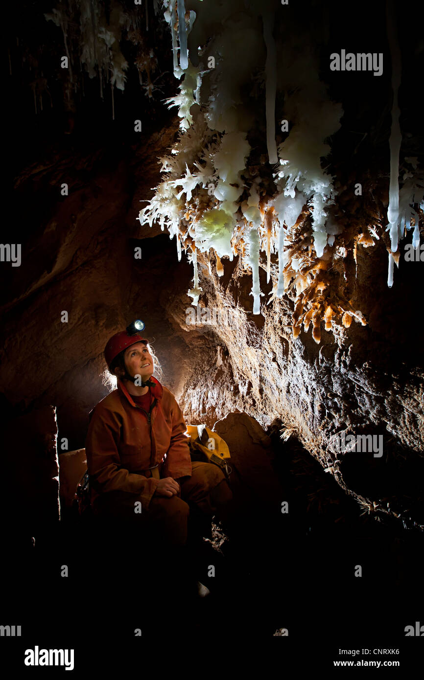 Woman caver looking at stalactites in a French cave France Stock Photo