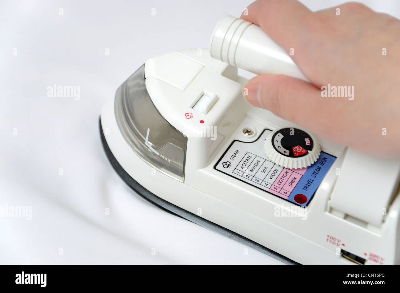 Electric iron on white satin Stock Photo Alamy