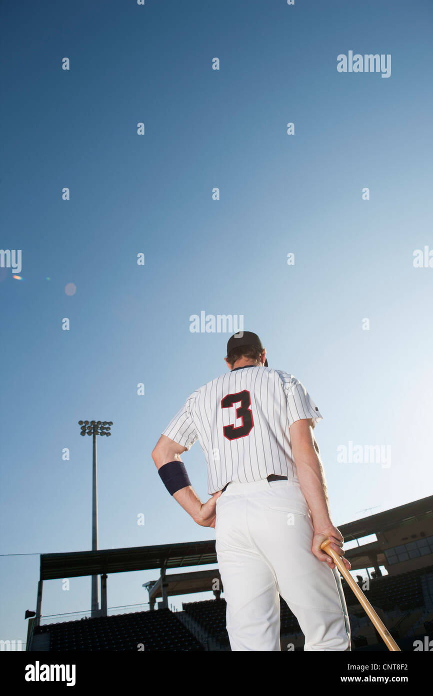 Baseball player standing with hand on hip, rear view Stock Photo Alamy