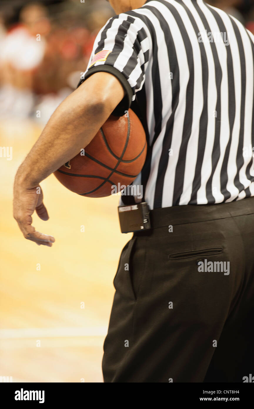 Basketball referee holding basketball, rear view Stock Photo