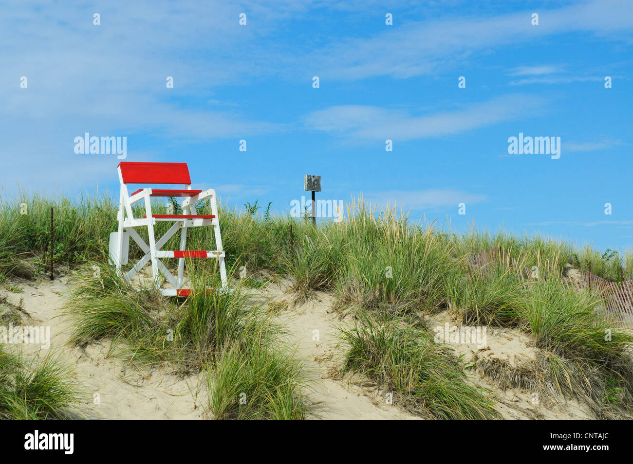 Empty red and white lifeguard chair on sand dune, Misquamicut State Beach, Westerly, Rhode Island USA Stock Photo