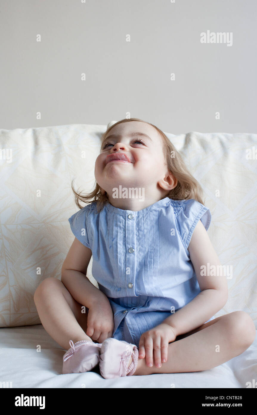 Toddler girl sticking tongue out, full length portrait Stock Photo
