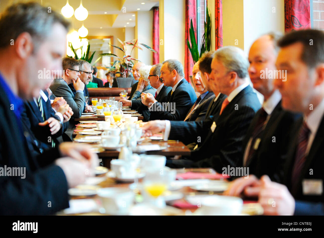 Business Networking Breakfast. Business men and women discuss forward