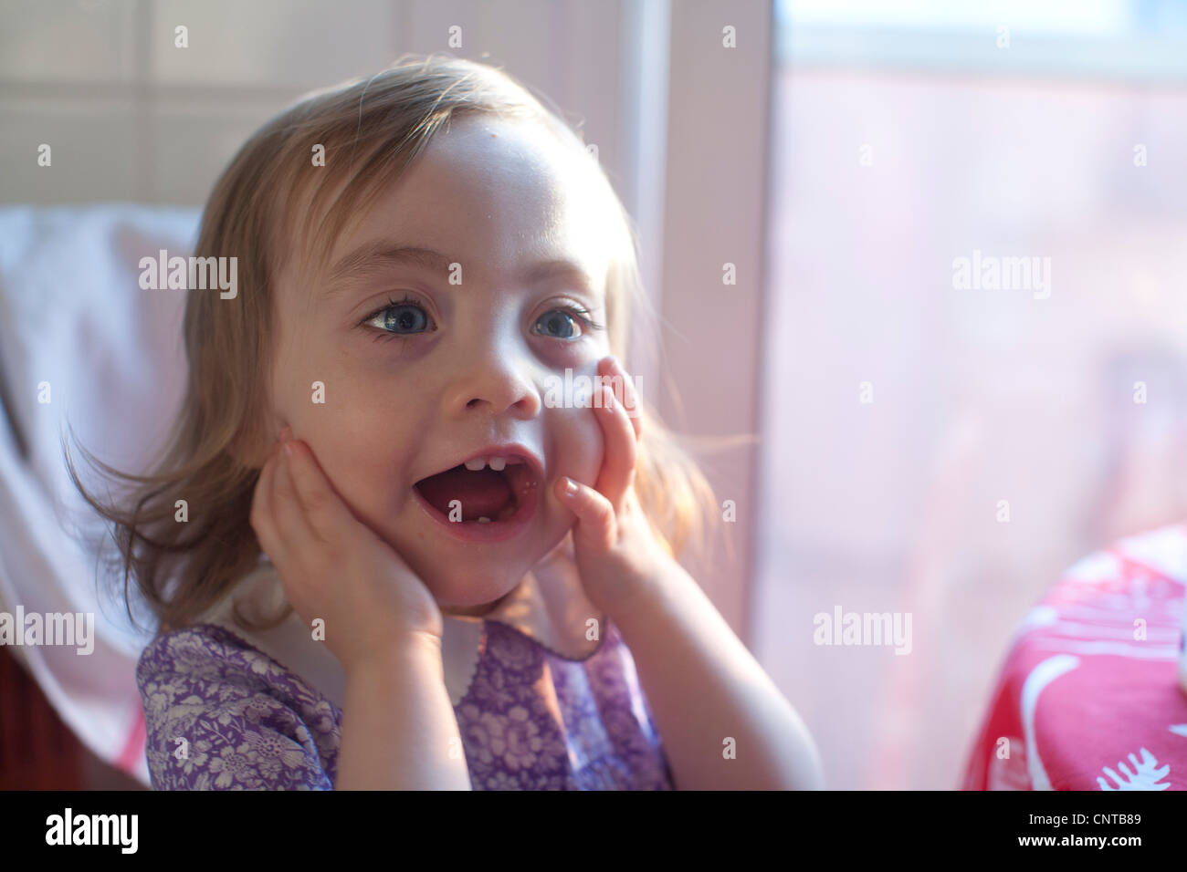Toddler girl with mouth open in surprise Stock Photo Alamy