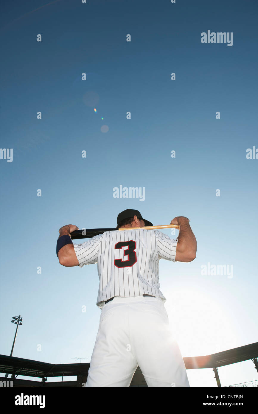 Baseball player holding bat, rear view Stock Photo