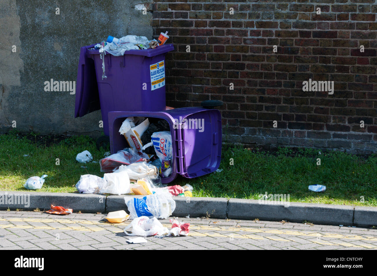 Rubbish spilt from an overturned wheely bin. Stock Photo