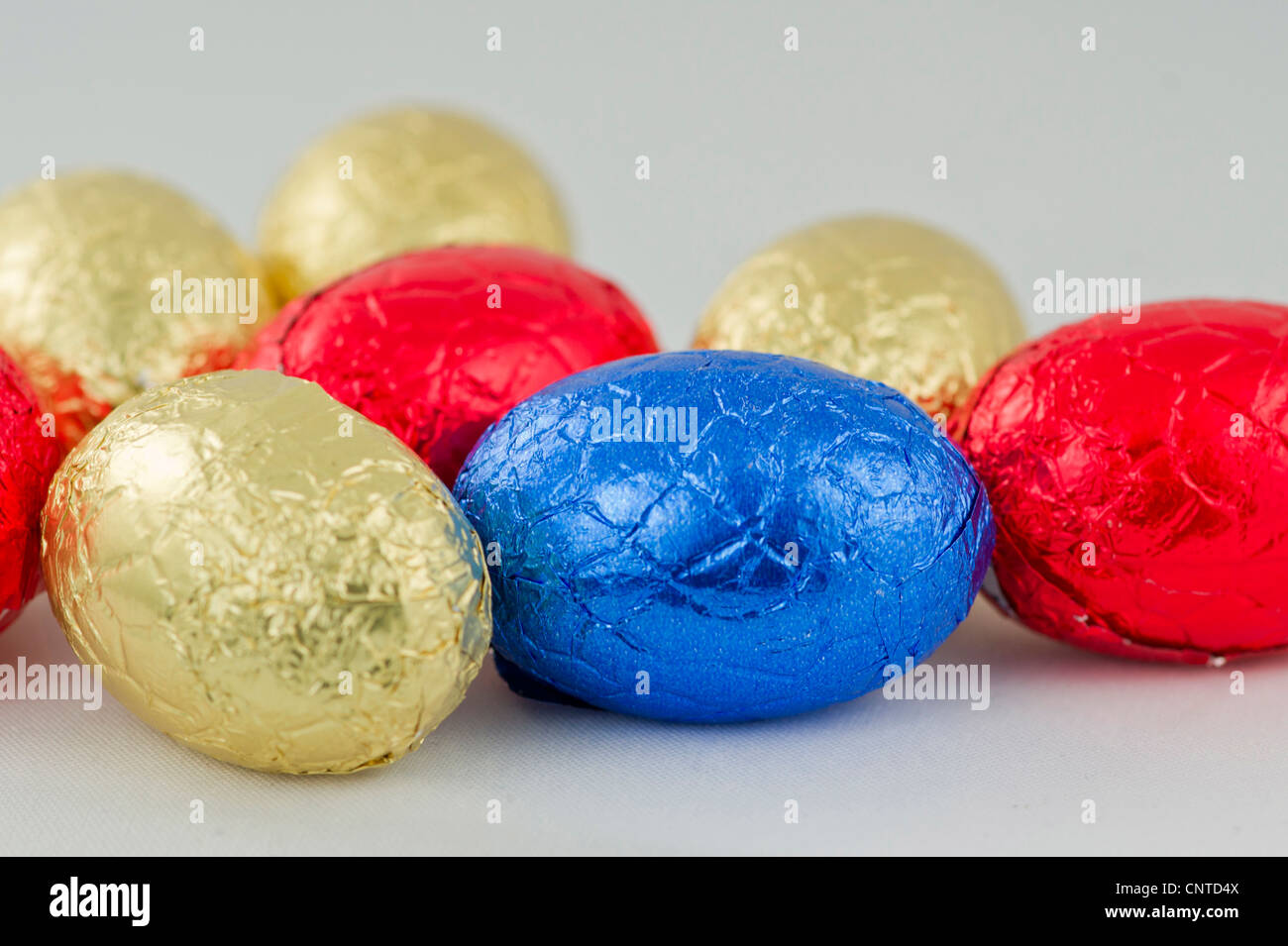 Chocolate Easter eggs in yellow,red and blue wrappings Stock Photo