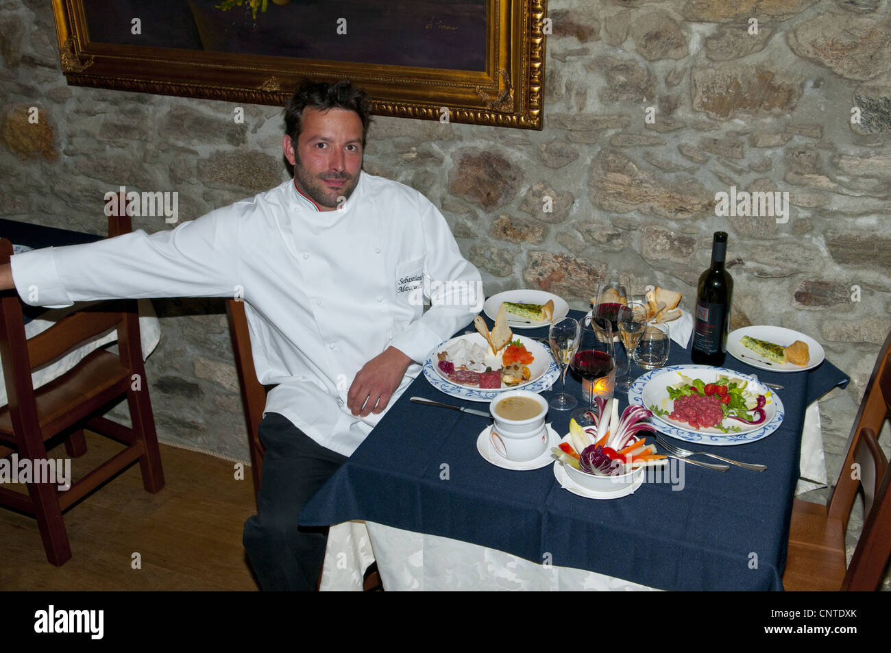 italian cook at the table with his plate, Lake orta, Piedmont, Italy Stock Photo