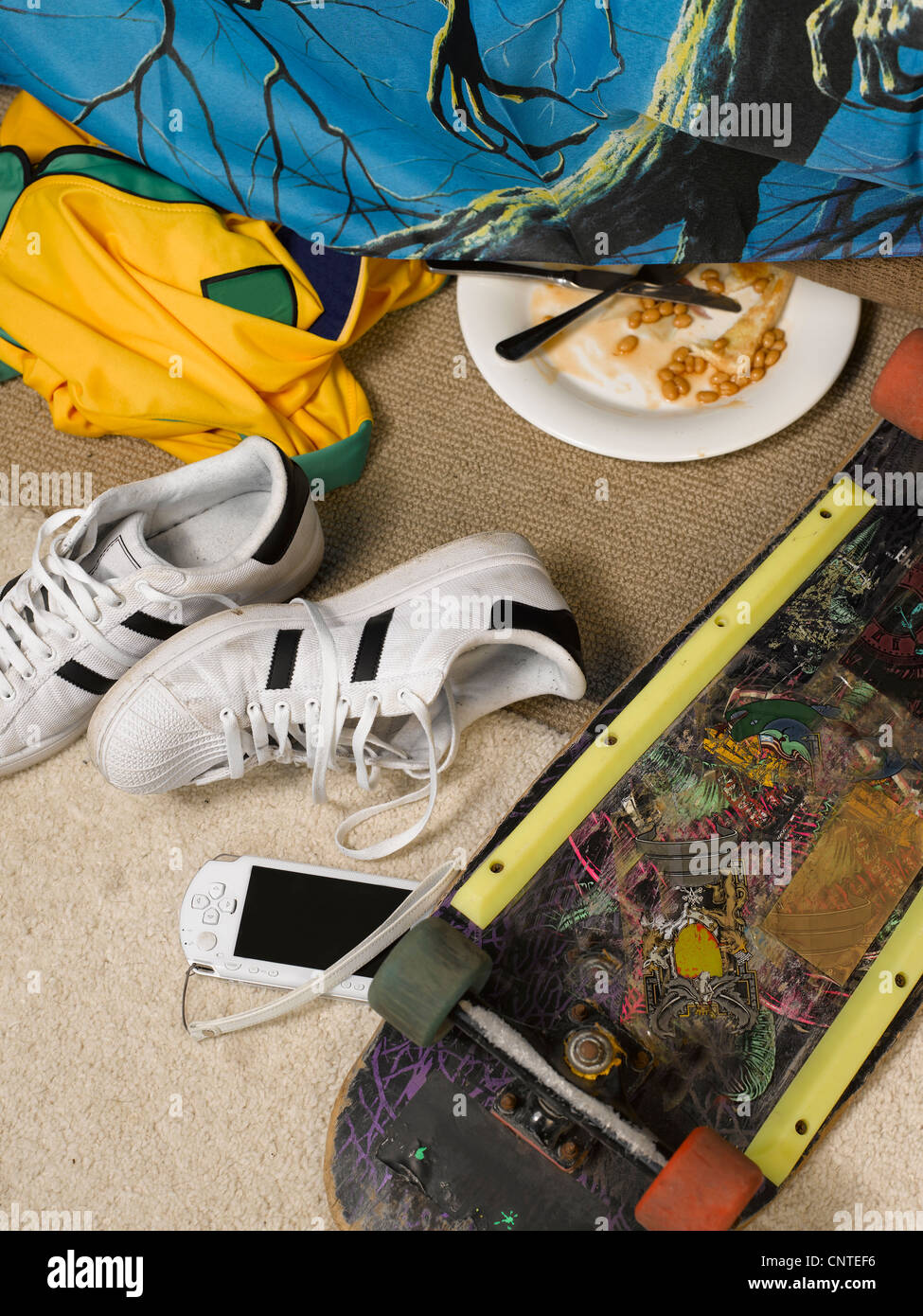 Cell phone and skateboard in bedroom Stock Photo