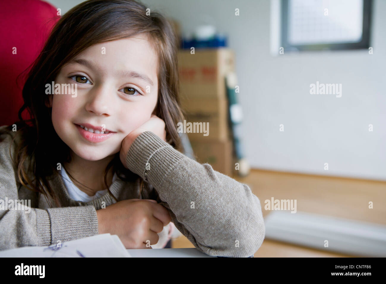 Smiling girl sitting at desk Stock Photo