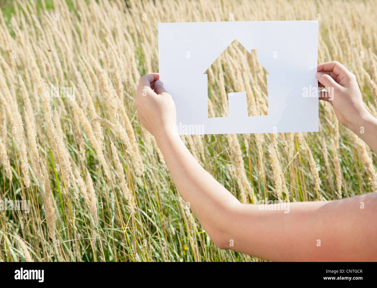 Woman holding paper house cut out Stock Photo