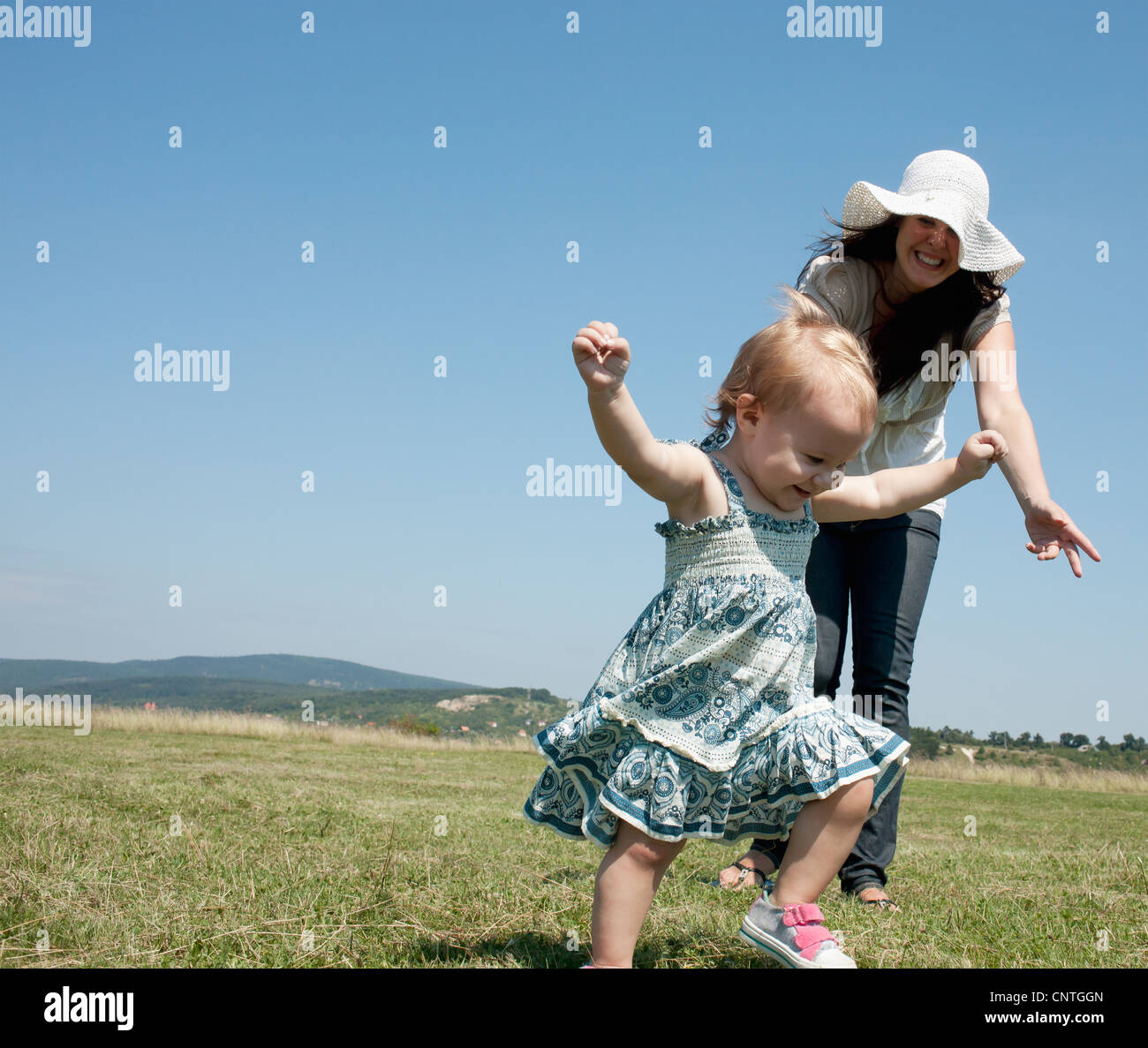 Mother and daughter walking in field Stock Photo