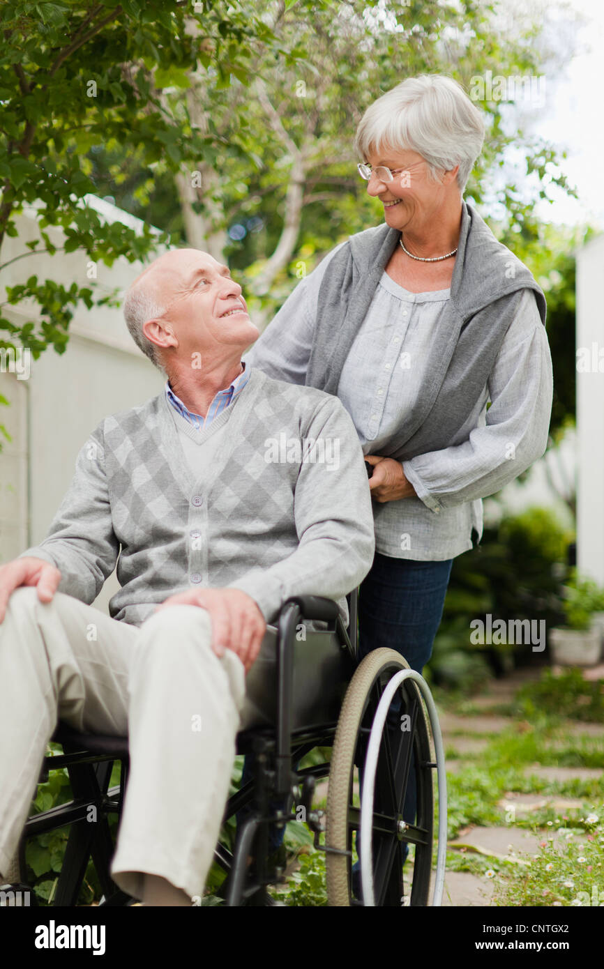 Nurse wheeling older patient outdoors Stock Photo