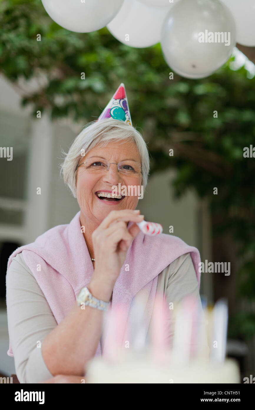 Older woman laughing at birthday party Stock Photo