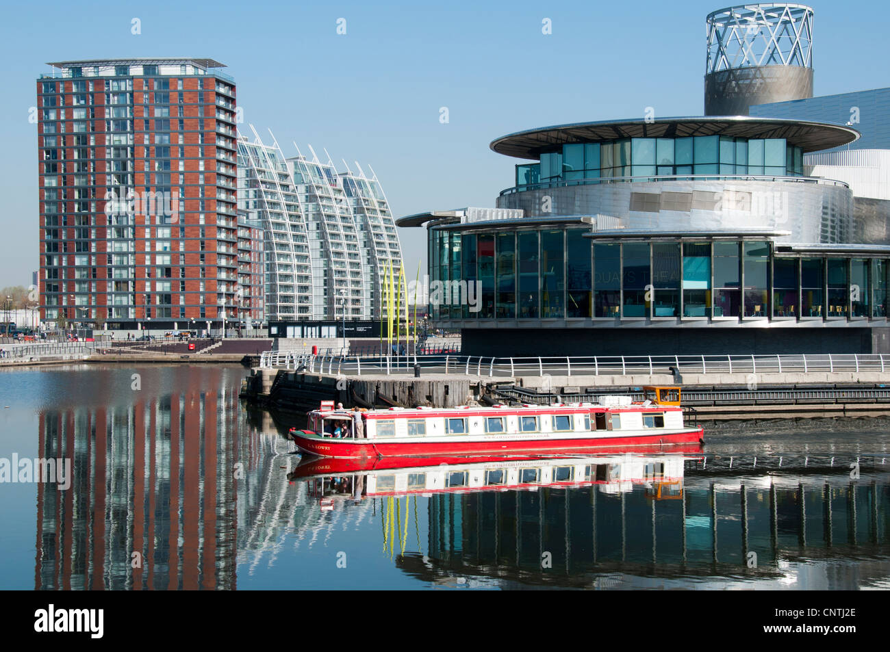 The L.S.Lowry tour boat passes the Lowry Arts Centre at Salford Quays, Manchester, England, UK Stock Photo