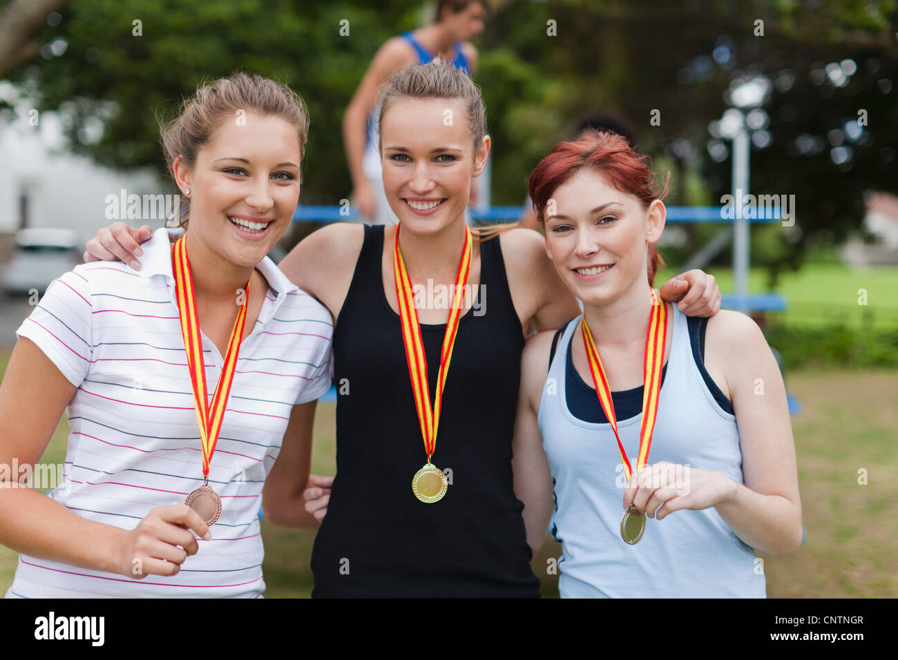 Women wearing medals in park Stock Photo