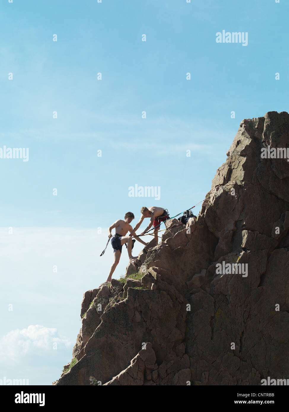 Rock climbers scaling steep rock face Stock Photo