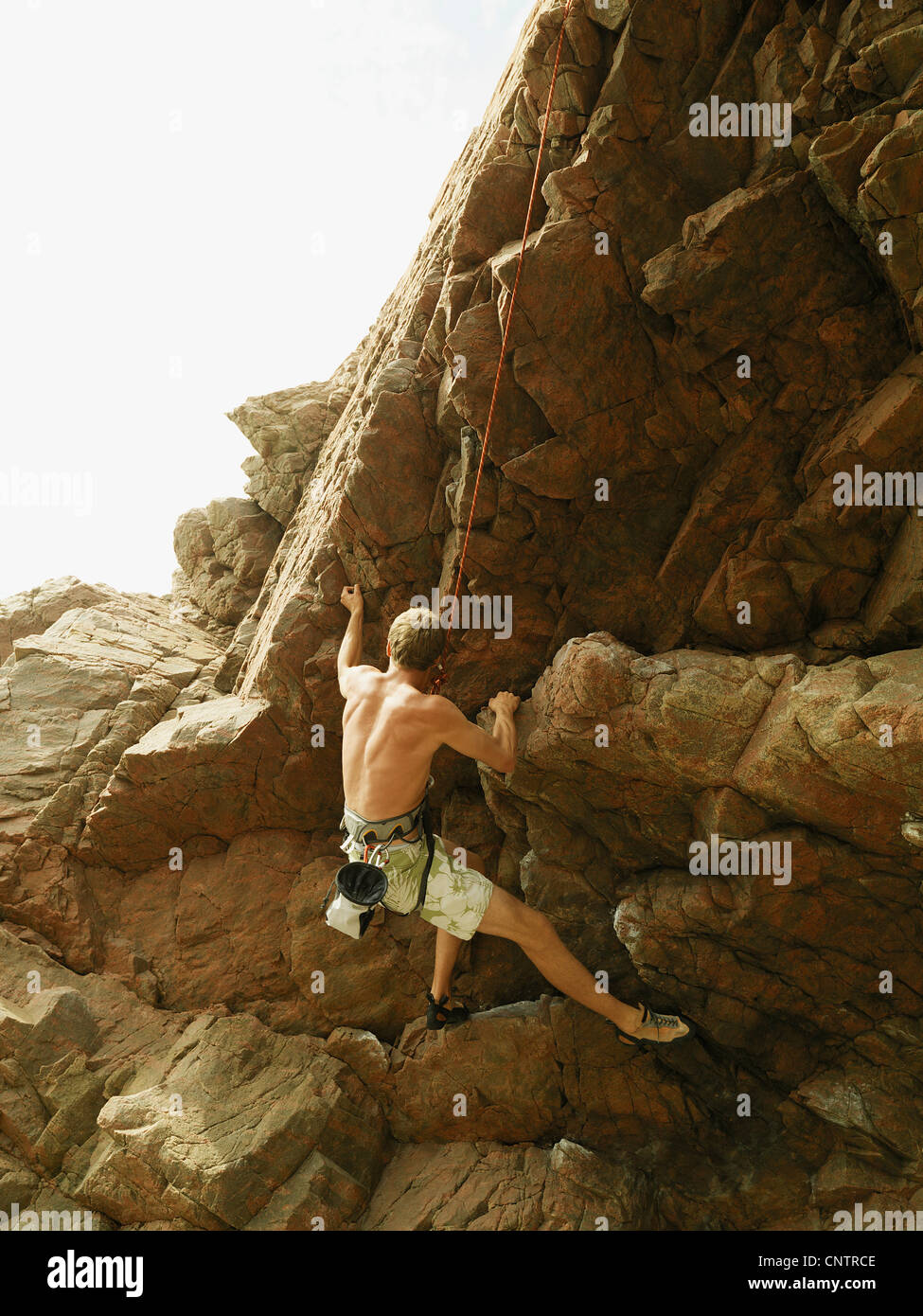 Rock climber scaling steep rock face Stock Photo