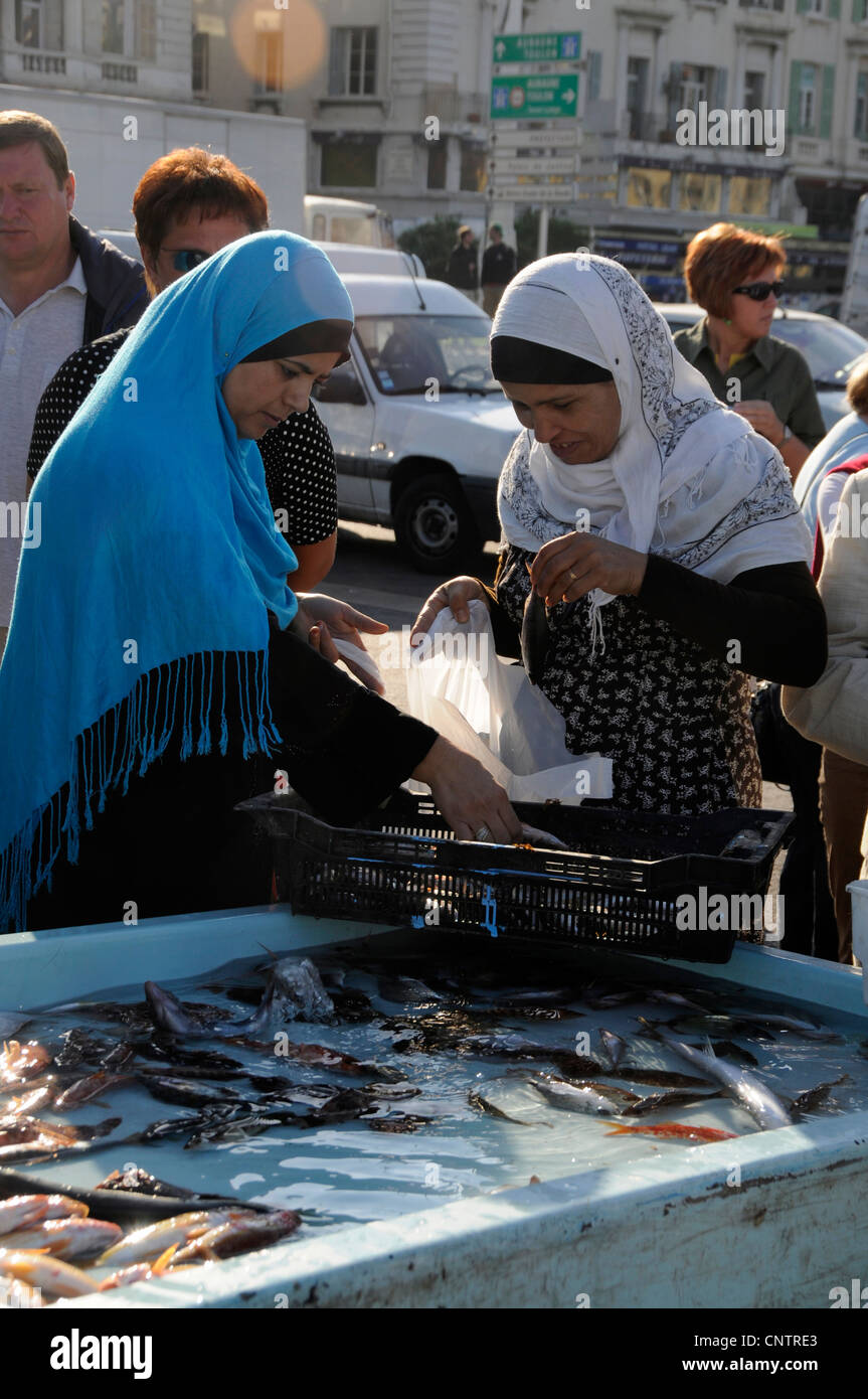 Two Muslim women enjoying a morning shopping at the daily fish market in Vieux port (old port) in Marseille, France Stock Photo