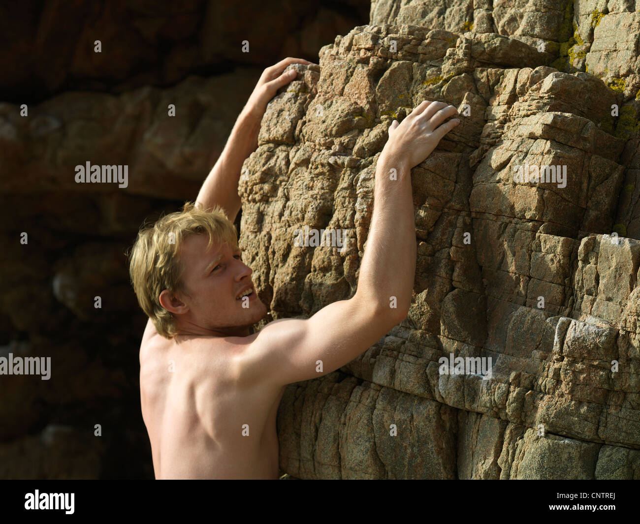 Rock climber scaling steep rock face Stock Photo