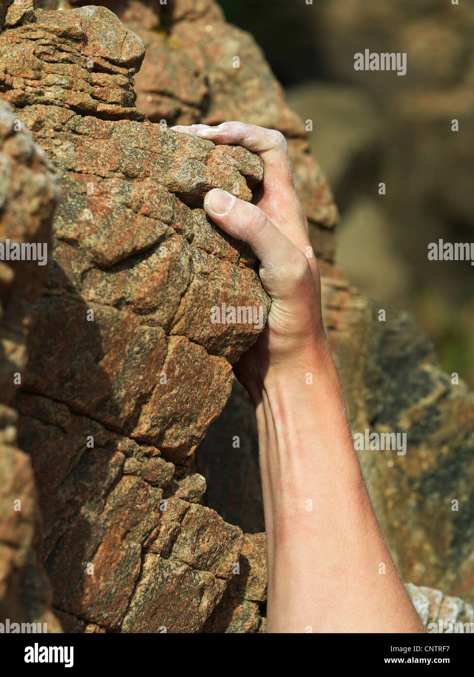 Rock climbers hand on steep rock face Stock Photo