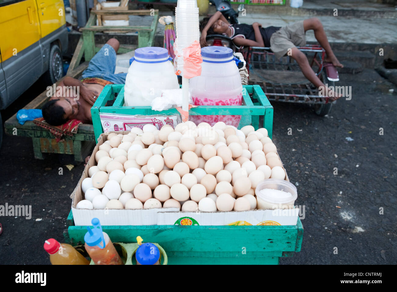 Workers sleeping next to a roadside stall selling Balut, a fertilized duck embryo. Carbon Market, Cebu City, Philippines. Stock Photo