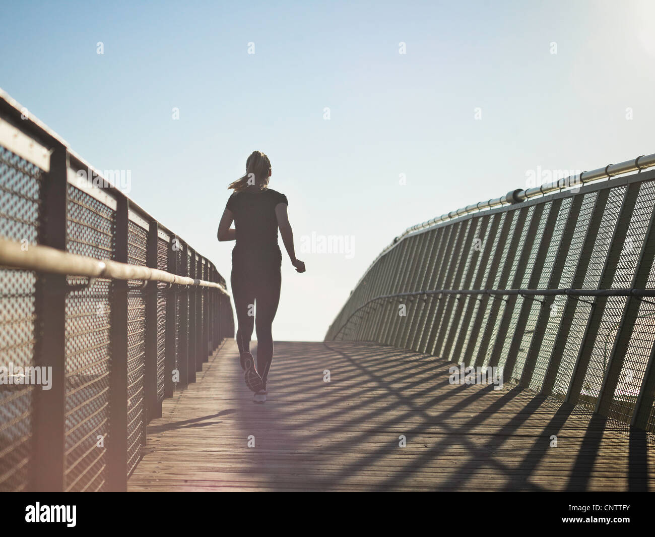 Woman running on skybridge Stock Photo